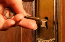 A hand sticking a key in a lock