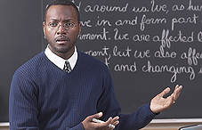 Teacher satnding in front of chalk board Teacher satnding in front of chalk board