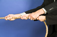 People in suits pulling a rope People in suits pulling a rope