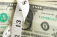 Measuring tape wrapped around dollars Measuring tape wrapped around dollars