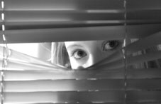Girl looking through blinds