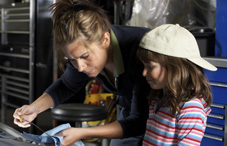 Woman working with daughter in garage