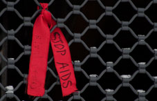 A "Stop Aids" ribbon tied to a gate A "Stop Aids" ribbon tied to a gate
