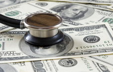 Stethoscope on top of hundred dollar bills