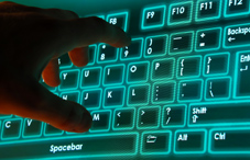 Hand on glowing computer keyboard Hand on glowing computer keyboard
