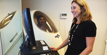 Dr. Tate uses equipment to measure body mass index.