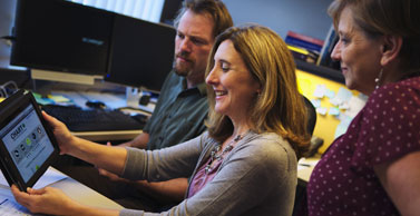 Dr. Tate reviews a website mockup on an iPad.