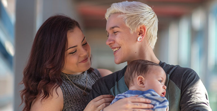 young LGBTQ couple holding their baby