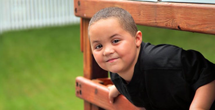young boy climbing on playground equipment