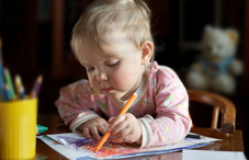 A baby coloring with a marker