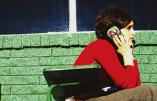 Girl with headphones in front of brick wall 