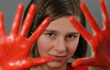 Girl with red paint on her hands