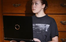 Girl up against her dresser on laptop