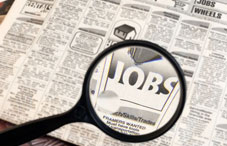 Jobs section in a newspaper with magnifying glass 