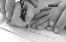 Someone helping kid to write