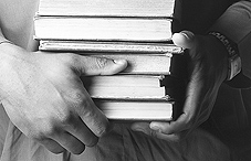 Someone holding a stack of books