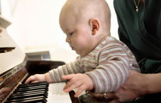 Baby on lap playing piano