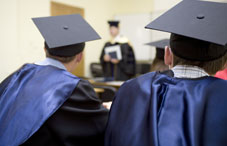 Students wearing cap and gown in a room