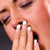 Woman with hand over mouth yawning