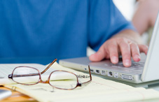Eye glass laying beside a laptop
