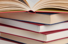 Open book on top of other books