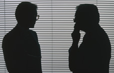 Silhouette of two people talking