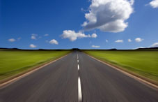 Road between grass fields