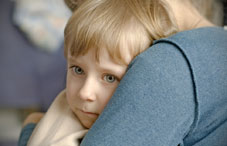 Pensive child on lap of parent