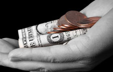 Hand holding a dollar and coins