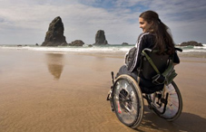 Young woman in wheelchair on beach