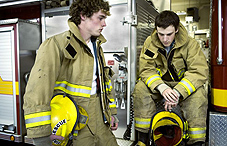 Two firemen around the fire truck  