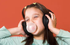 Girl wearing headphones and blowing a bubble 