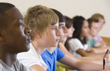Students sitting side-by-side taking notes 