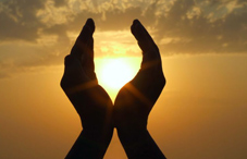 Silhouette of divine hands in sunset