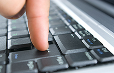 Finger on enter key of computer keyboard