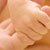 Infant gripping adult's finger