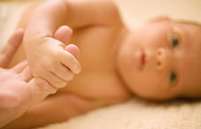 Infant gripping adult's finger