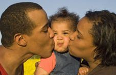 Family kissing baby
