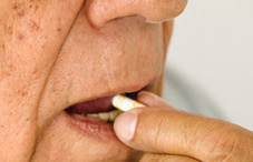 Elderly man taking pill