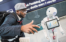Robot Josie Pepper assists passenger Nadio Garrido at Munich Airport on Feb. 20, 2018.
