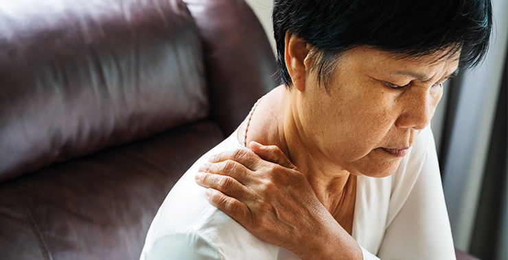 Woman in pain holding shoulder 