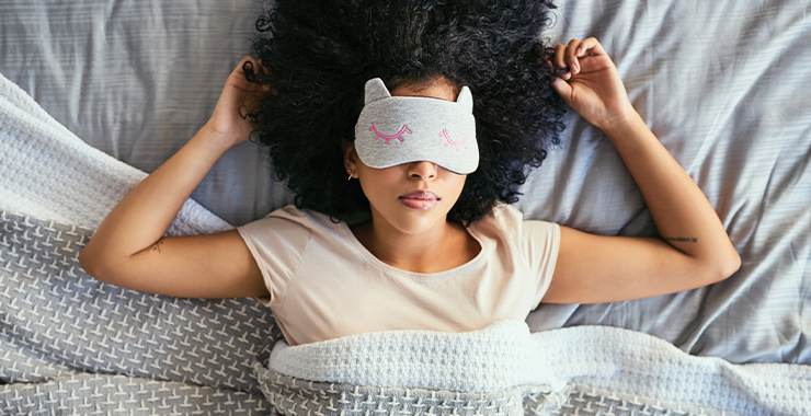 Woman on her back in sleeping with a sleep mask on her face