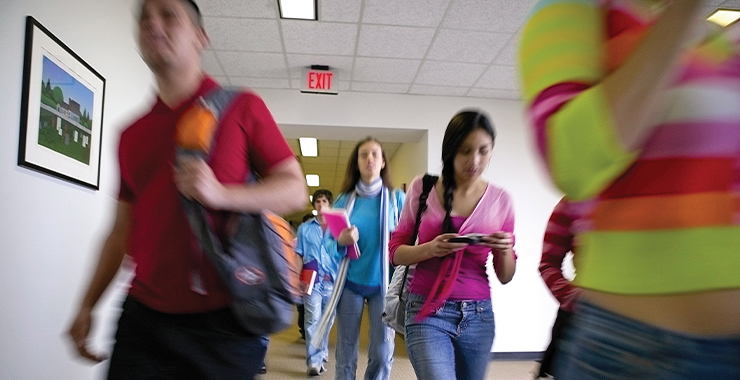 Group of teens walking in a school hallway