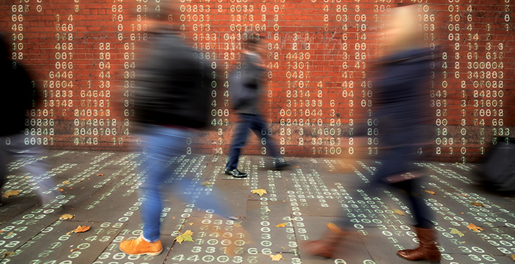 People walking on the street with binary numbers overlay.