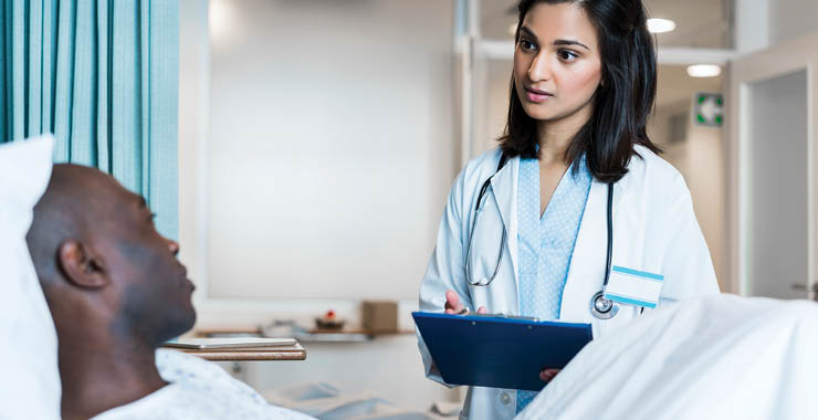 Monitor on Psychology: June; doctor with chart talking to patient in bed
