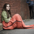 Homeless woman sitting on a sidewalk with a sleeping bag