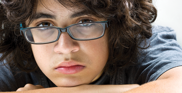Immigrant child with glasses looking very sad