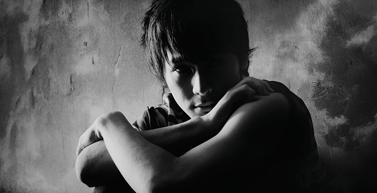 Young boy sitting with arms crossed