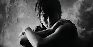 Young boy sitting with arms crossed