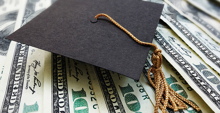 Graduation cap resting on a pile of money